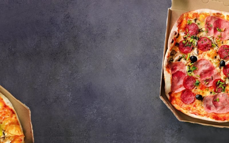 fresh-pizza-in-delivery-box-on-grey-concrete-2R26DTY-min.jpg